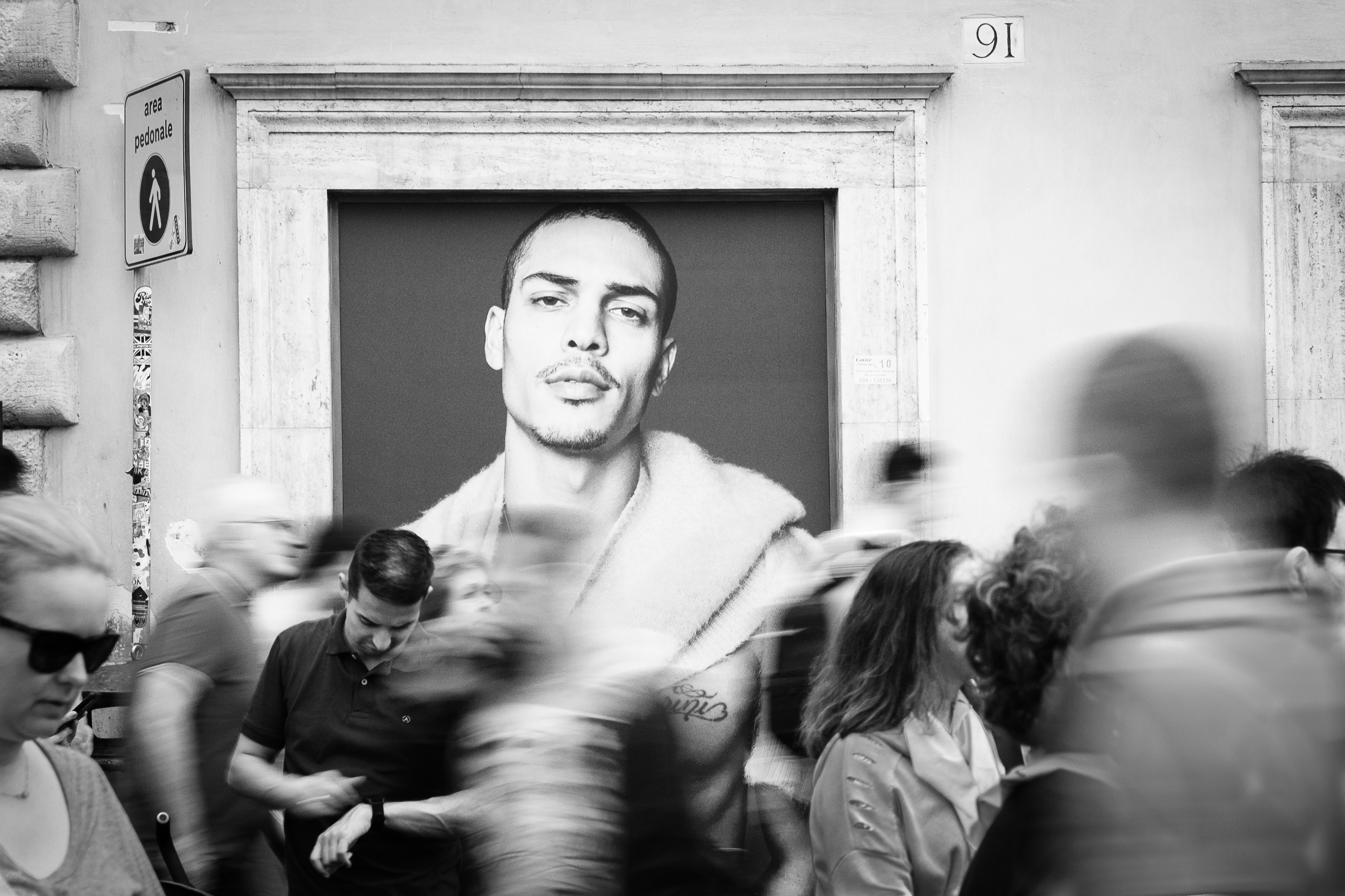 Man on billboard with crowd rushing infront of it